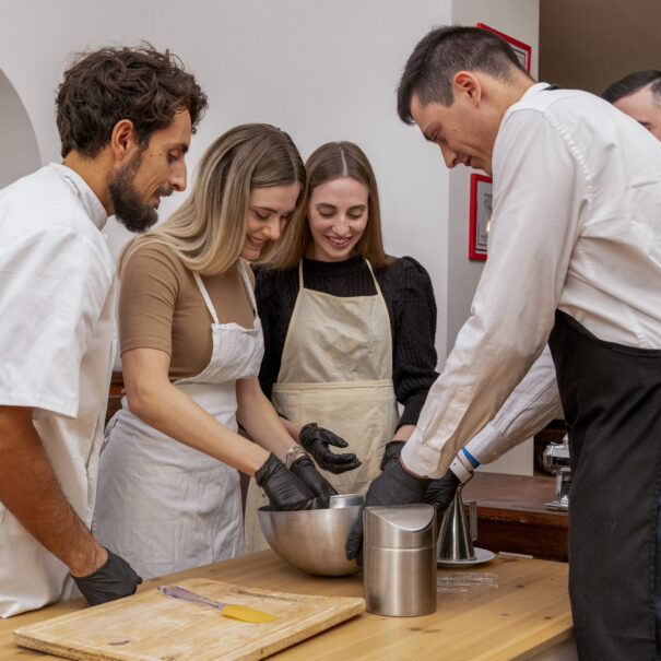 Ospiti impastano la pasta fresca durante un corso di cucina nel Home Restaurant InVilla del B&B Villa LeMarche.
